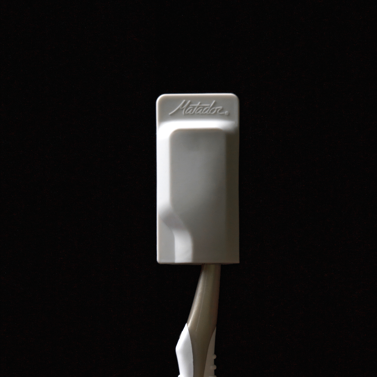 White cap on toothbrush on black background