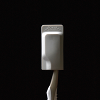 White cap on toothbrush on black background