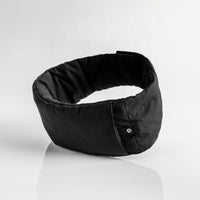 circular black eye mask sitting on reflective light gray background