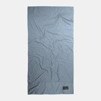 Top-down view of full slate blue towel on light gray background