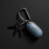 Blue Droplet silicone case connected to black carabiner on black background