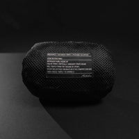 Packed down backpack pouch on black background