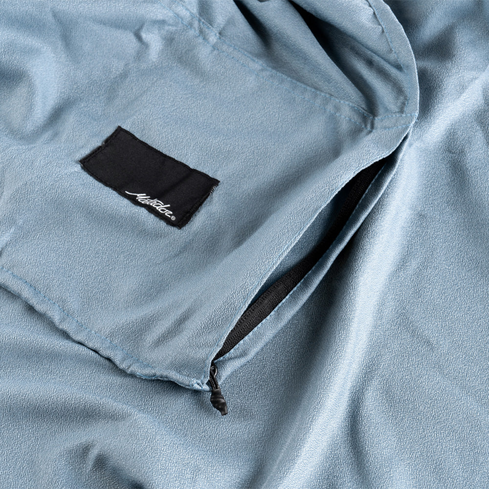 Close up view of zipper pocket on slate blue towel