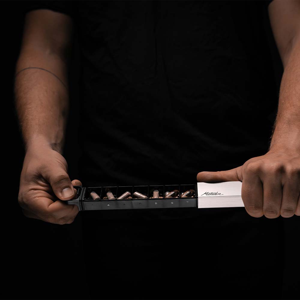 Man holding fully open pill slider on black background