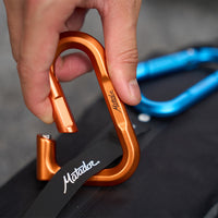 hand unclipping orange betalock with blue betalock in the backgorund