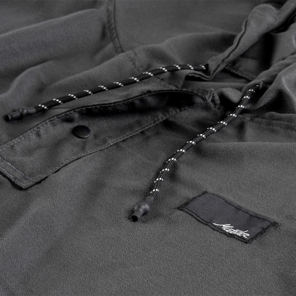 Close up view of charcoal poncho details including hood pull stings and snap button collar