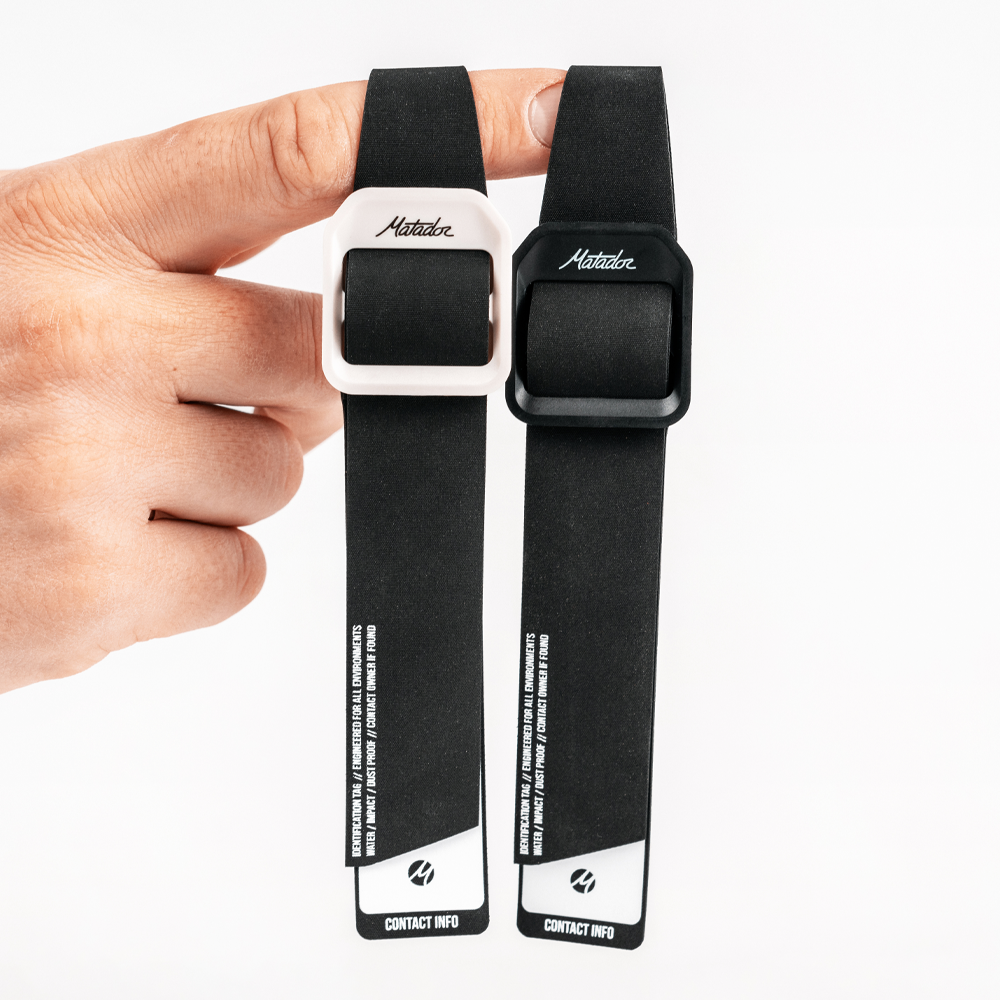 Close up of hand holding black and white gear tags by finger