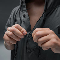 close up view of man buttoning up towel poncho snaps