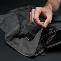 close up studio photo of cell phone being placed in charcoal beach towel pocket
