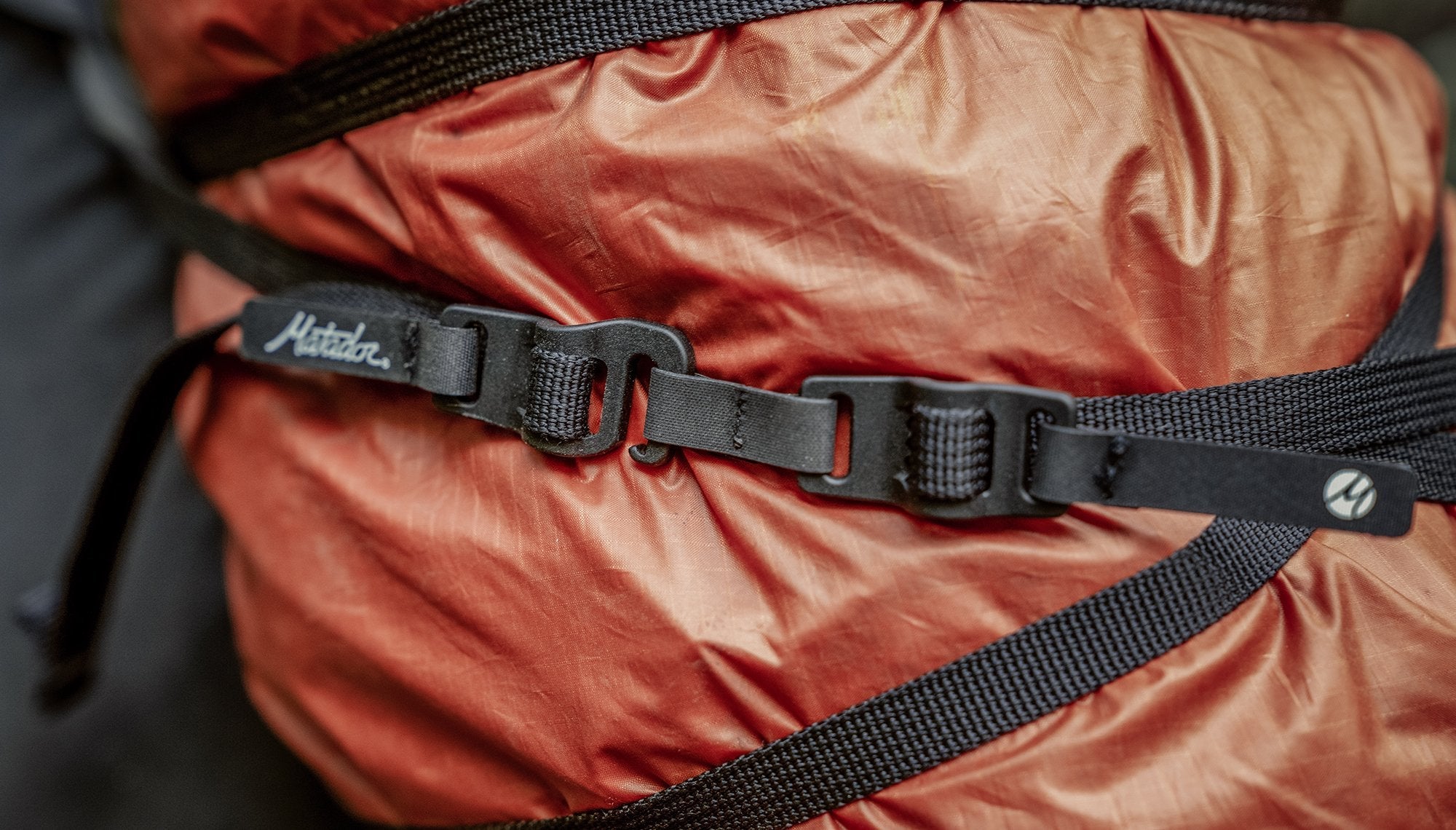 Close up of Better Tether hooks secured around orange tarp